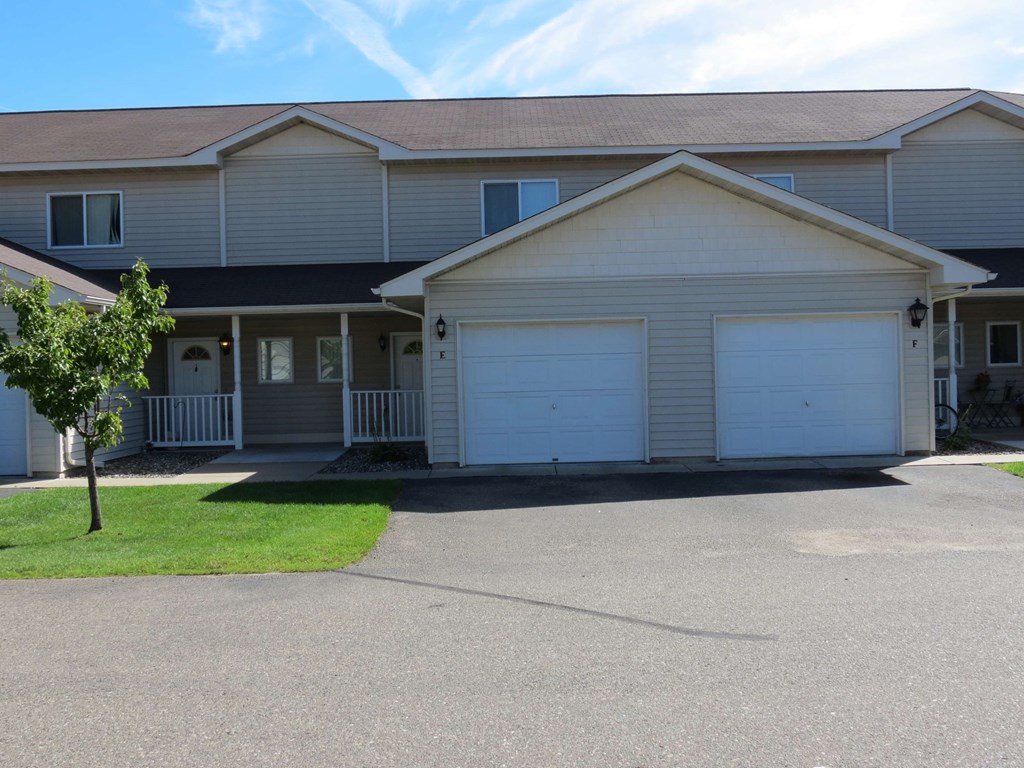 a white house with two garage doors and a lawn