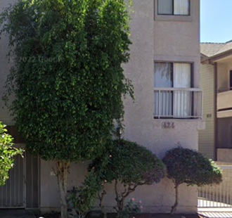 a building with a window and trees in front of it