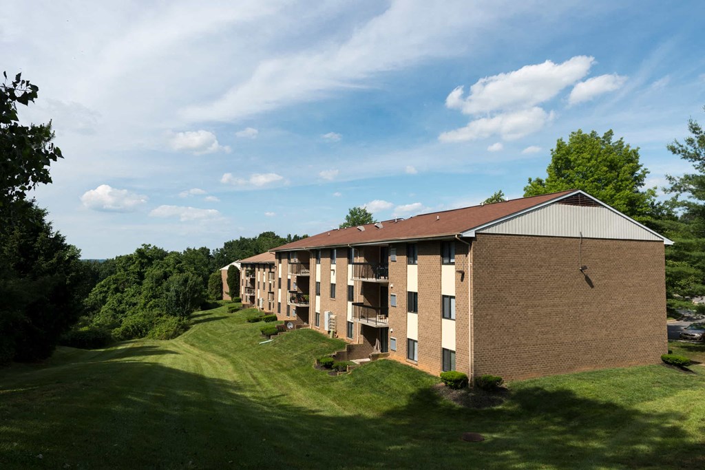 A large apartment complex with a grassy area in front.