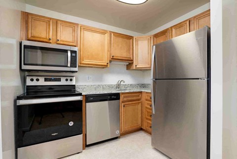 A kitchen with a stainless steel refrigerator, microwave, oven, and dishwasher.