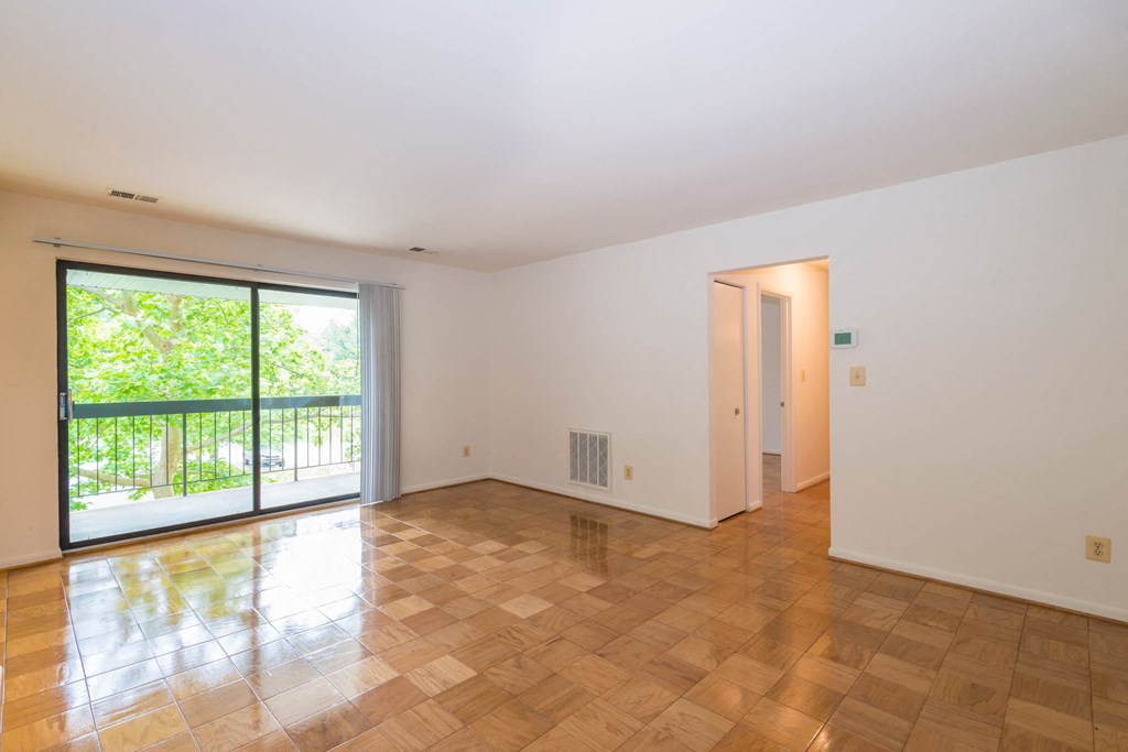 A room with a wooden floor and a sliding glass door.