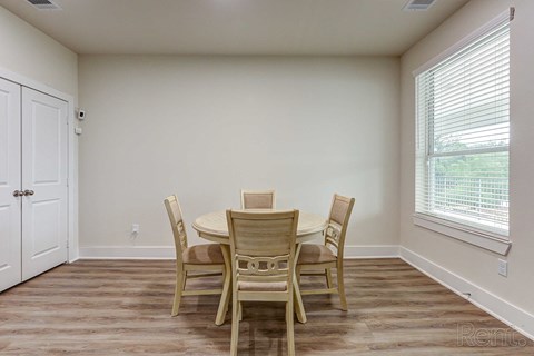 a dining room with a table and chairs and a window