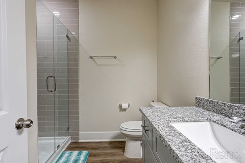 a bathroom with a toilet and a shower and a sink