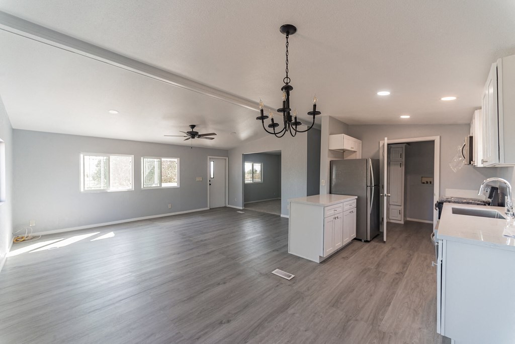 an empty kitchen and living room with a chandelier