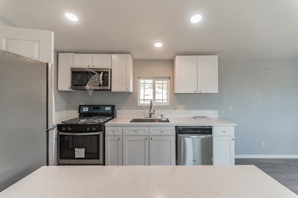 a kitchen with white cabinets and a white counter top