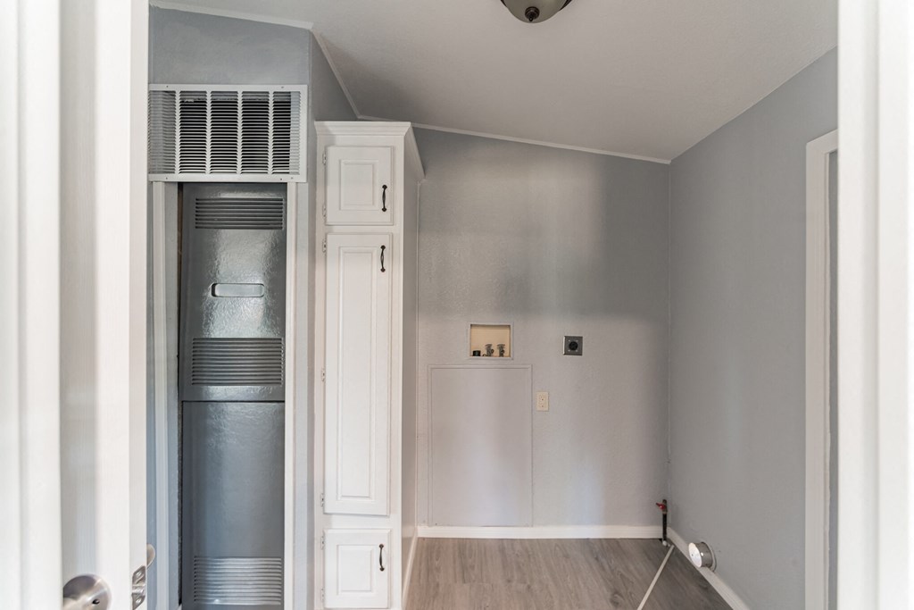 an empty room with a refrigerator and a closet