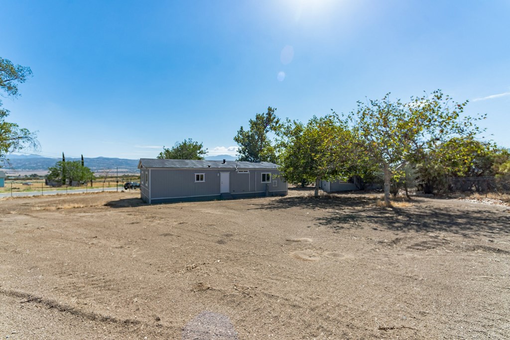 a small mobile home is parked in the middle of a dirt field