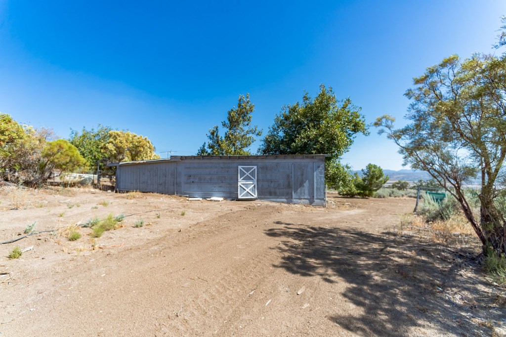 a shed and a barn on a dirt road