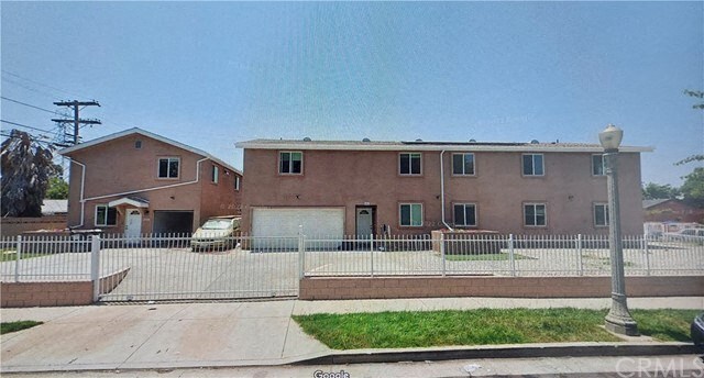a brick house with a white fence in front of it