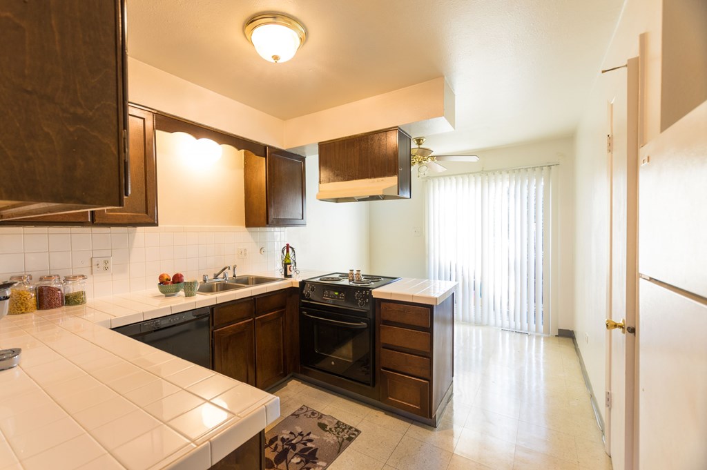 a kitchen with black appliances and wooden cabinets