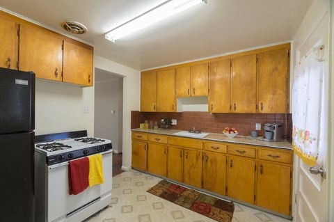 A kitchen with wooden cabinets and a black stove top.