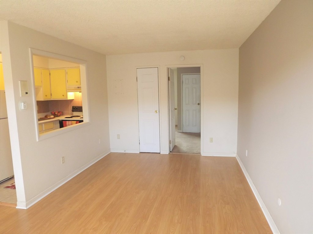 an empty living room with white walls and wood floors