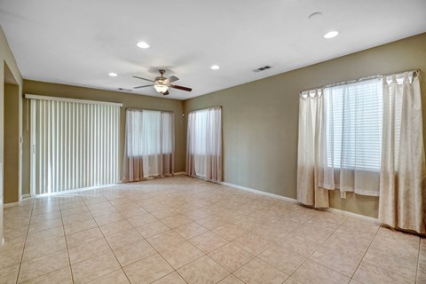 A spacious room with a ceiling fan and lighting fixtures.