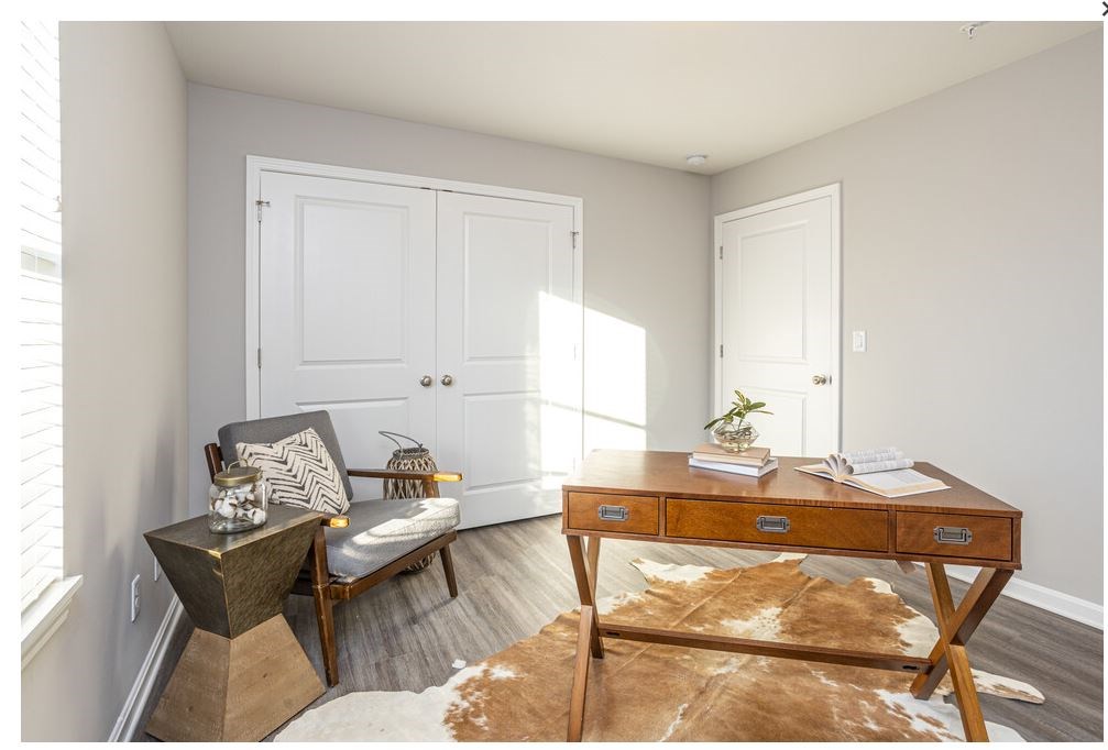 a room with a desk and a chair and two doors