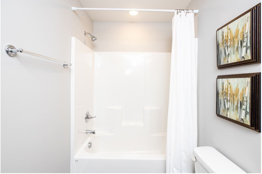a white bathroom with a shower and a tub