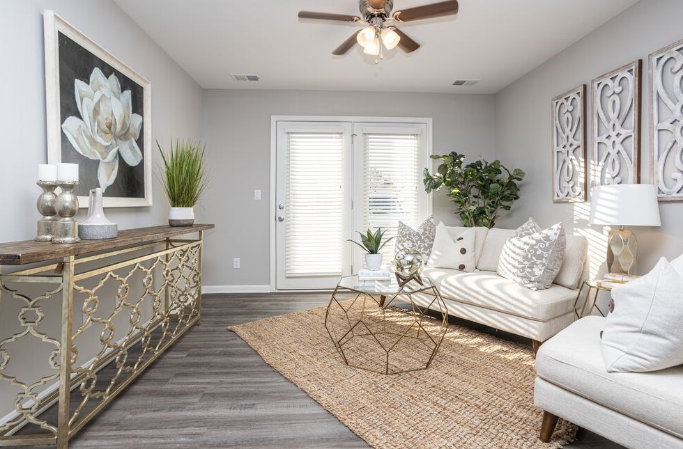 a living room filled with furniture and a ceiling fan