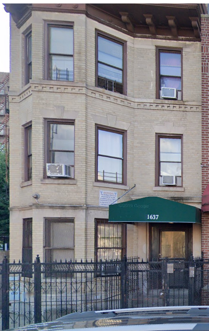 a brick building with a green awning and windows