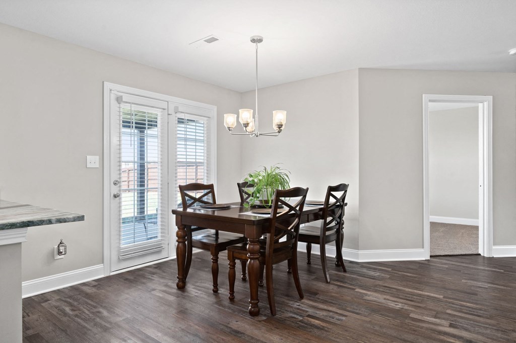 a dining room with a wooden table and chairs