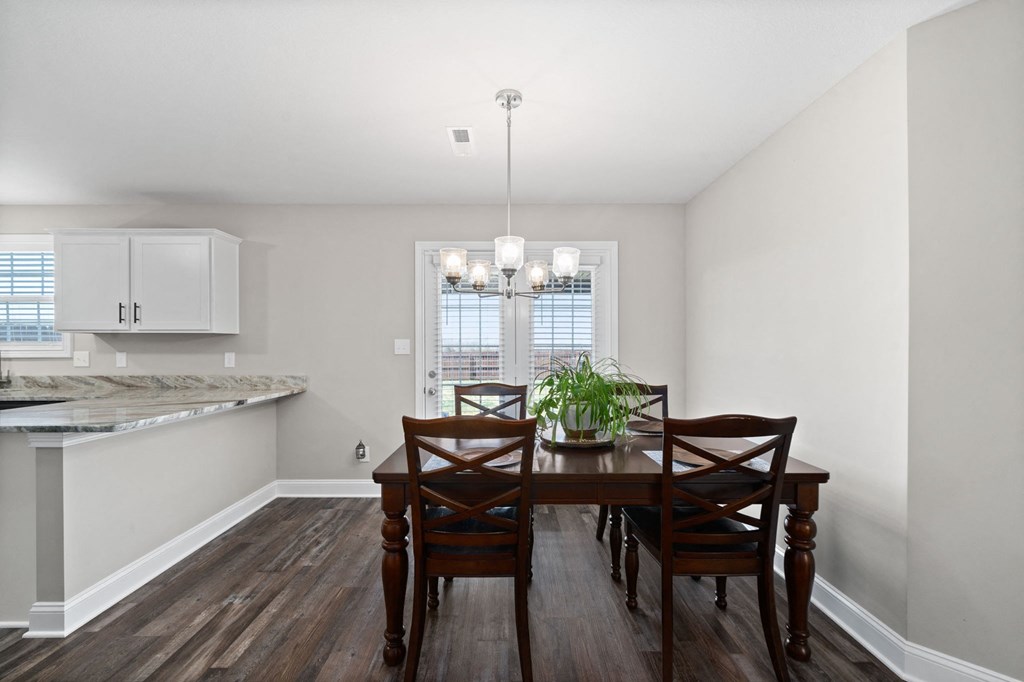 a dining room with a wooden table and chairs