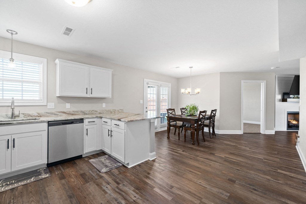a kitchen with white cabinets and a dining room with a table