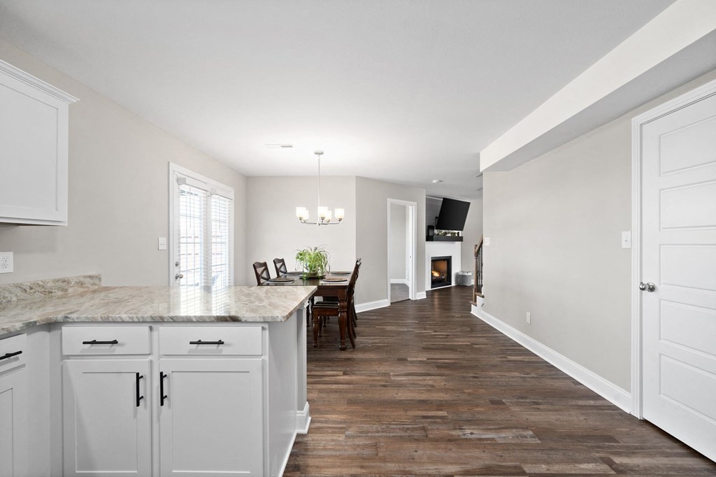 a kitchen with white cabinets and a marble counter top