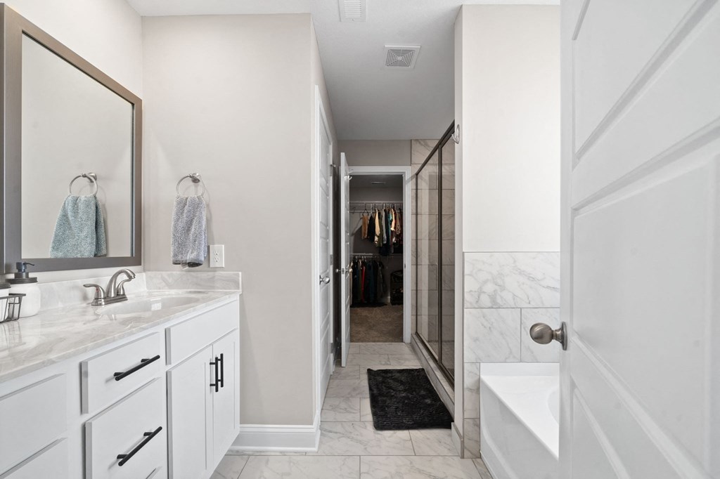 a bathroom with a shower and a sink and a mirror
