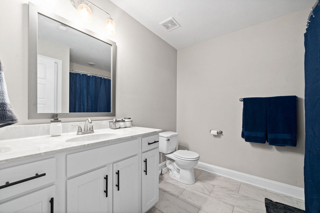 a bathroom with a large mirror and a toilet and sink