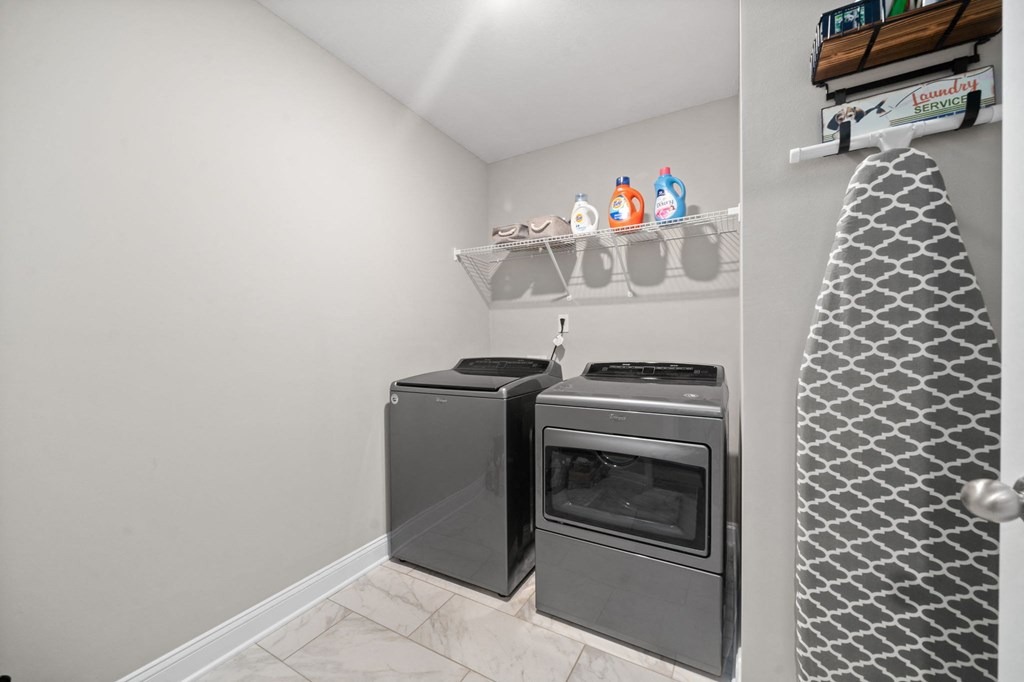 a laundry room with a stove and a washer and dryer in a house