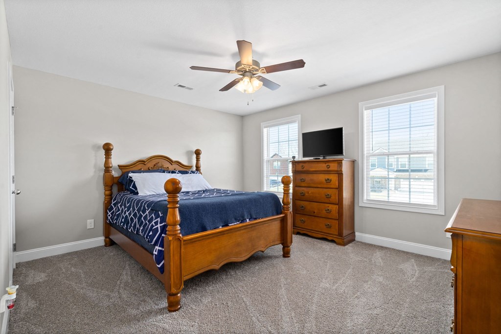 a bedroom with a bed and a ceiling fan