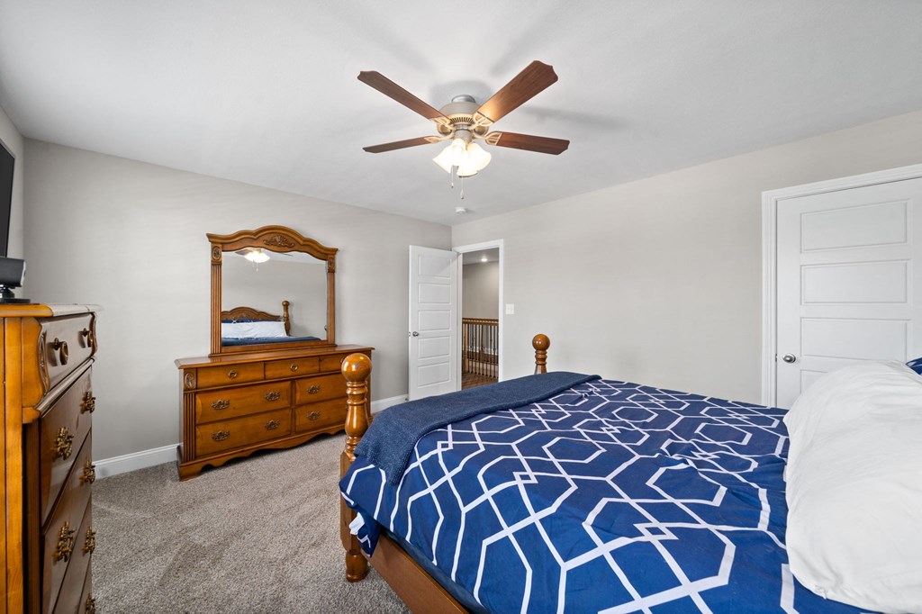 a bedroom with a bed and a ceiling fan