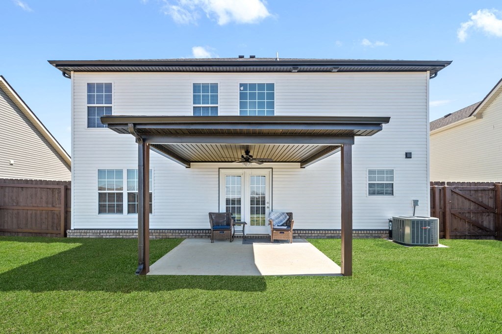 a covered patio in front of a white house