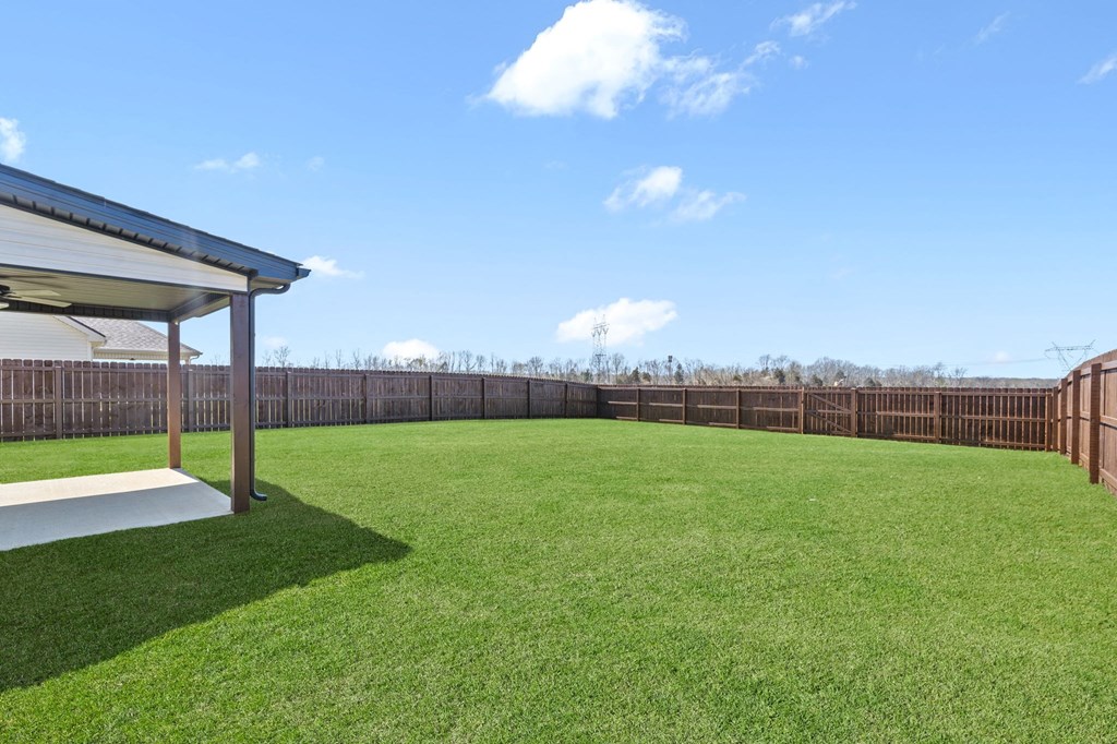 a backyard with a lawn and a fence