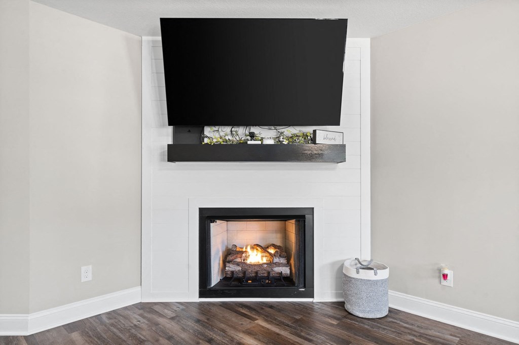 a white fireplace with a tv above it in a living room