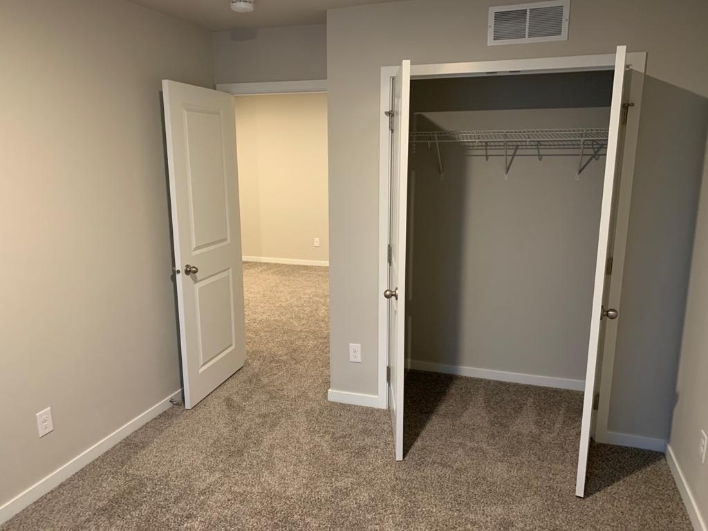 A room with a white door and a closet with a white door.