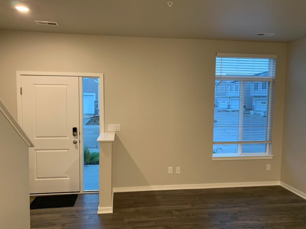 A room with a white door and a window with blinds.