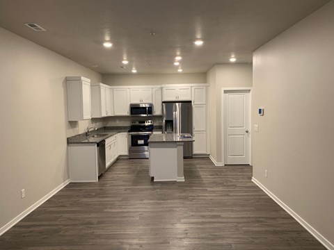 A kitchen with white cabinets and a refrigerator.
