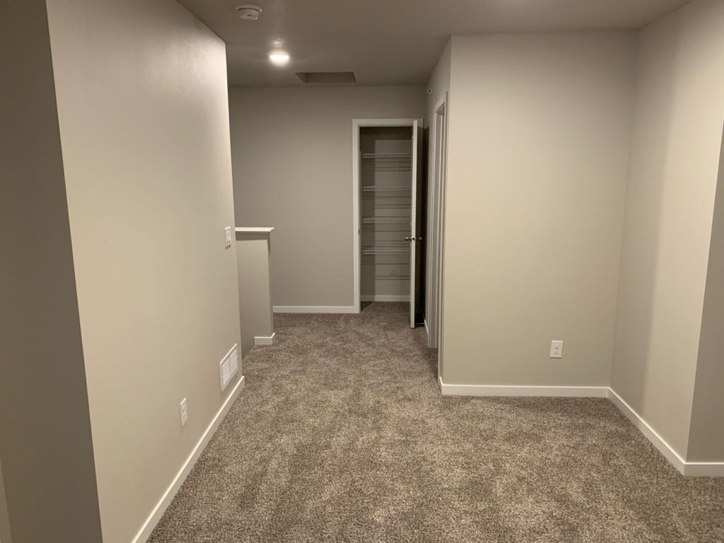 A room with a carpeted floor and a white door.