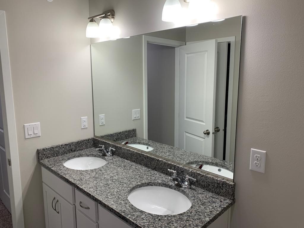 A bathroom with two sinks and a large mirror.