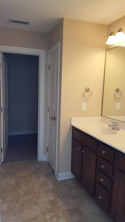 A bathroom with a sink, mirror, and cabinets.
