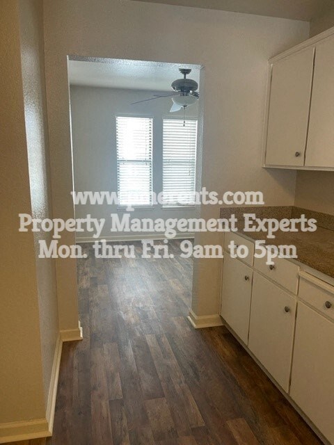 a kitchen with white cabinets and a ceiling fan