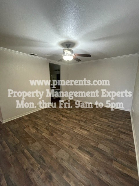 a living room with a ceiling fan and a wood floor