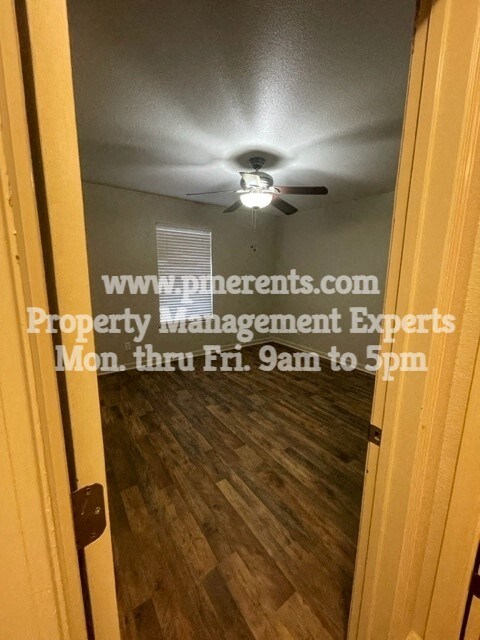 a door to a room with a ceiling fan