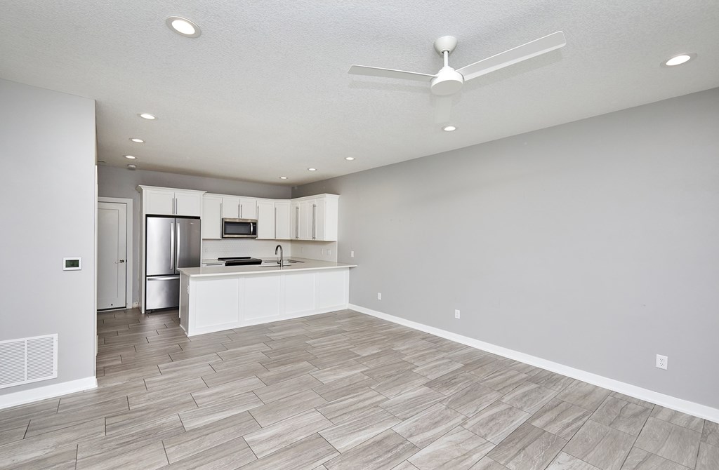 A spacious kitchen with a fan on the ceiling.