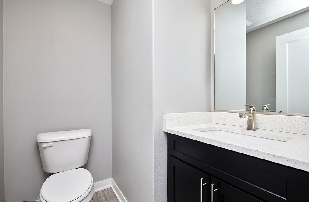A white toilet sits next to a sink in a bathroom.