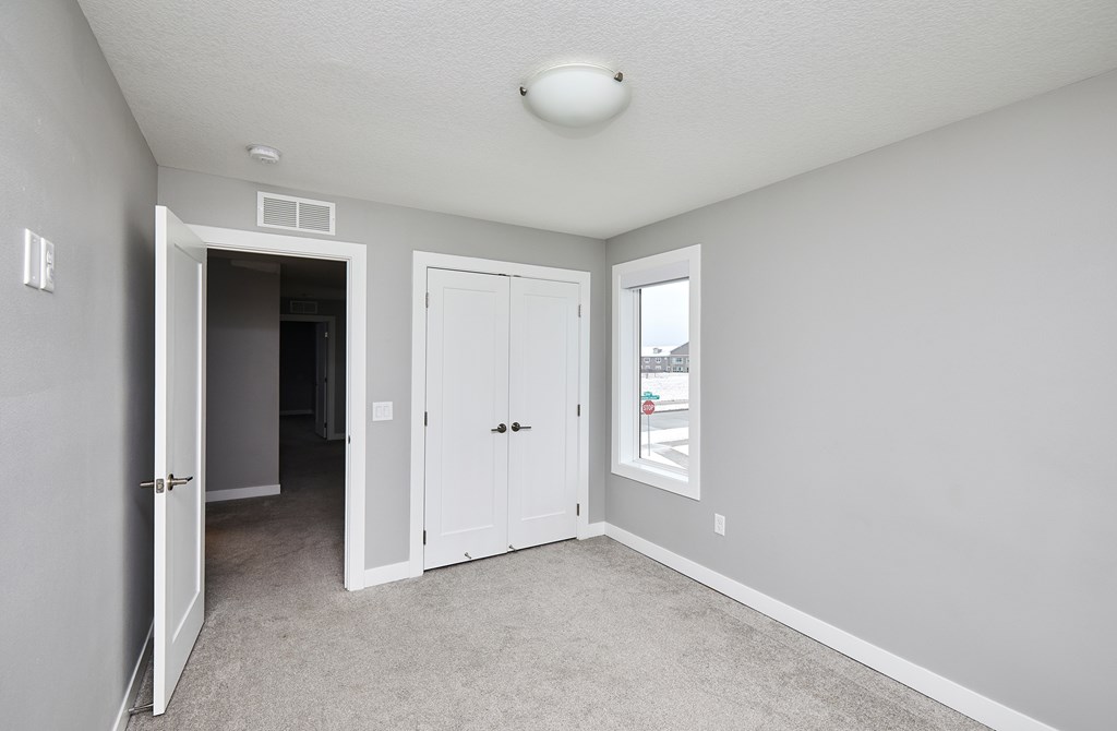 A room with a white door and carpeted floor.
