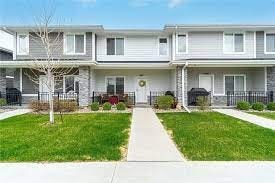 A row of houses with a white fence in front.