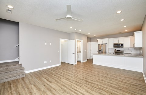 A spacious kitchen with a staircase on the left side.