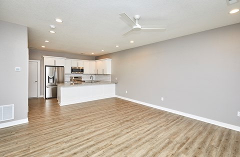 A spacious room with wooden flooring and a ceiling fan.