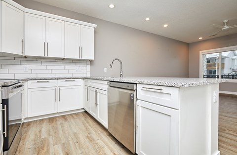 A kitchen with white cabinets and appliances.