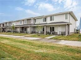 A row of houses with a grassy area in front.